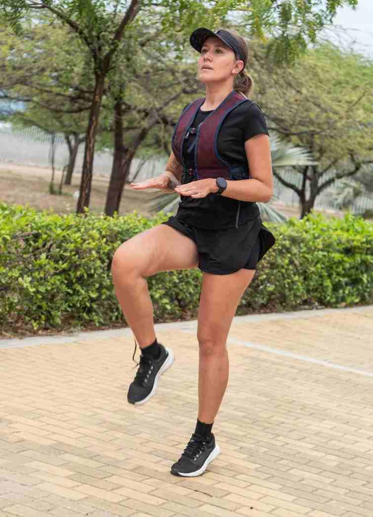 Person performing dynamic high-knee exercises in a park, showcasing dedication to outdoor fitness and high-intensity training.